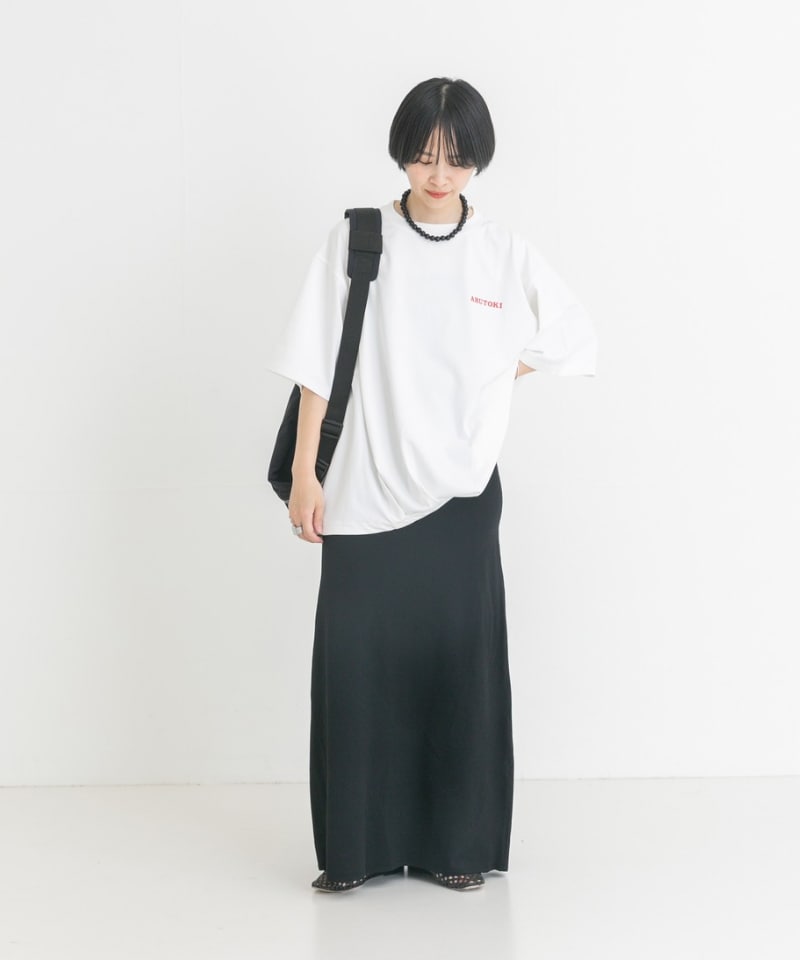 ブラック系のスカート、ホワイト系のTシャツ/カットソー、ブラック系のバックパック/リュックを着用したレディースの夏コーディネートの3枚目の写真