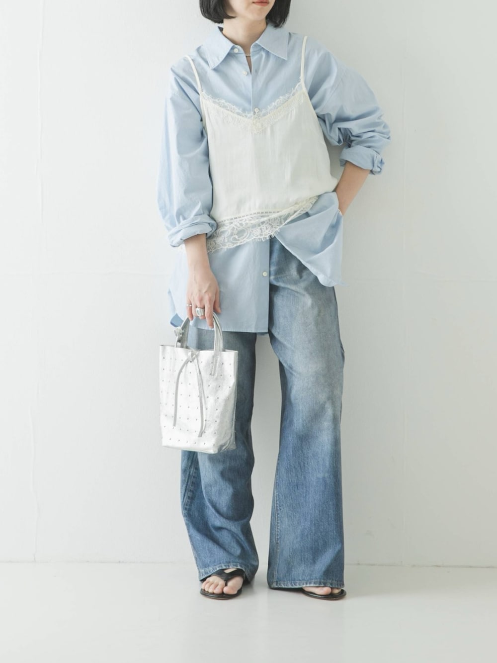 ホワイト系のキャミソール、ブルー系のシャツ/ブラウス、シルバー系のトートバッグを着用したレディースの春コーディネートの2枚目の写真