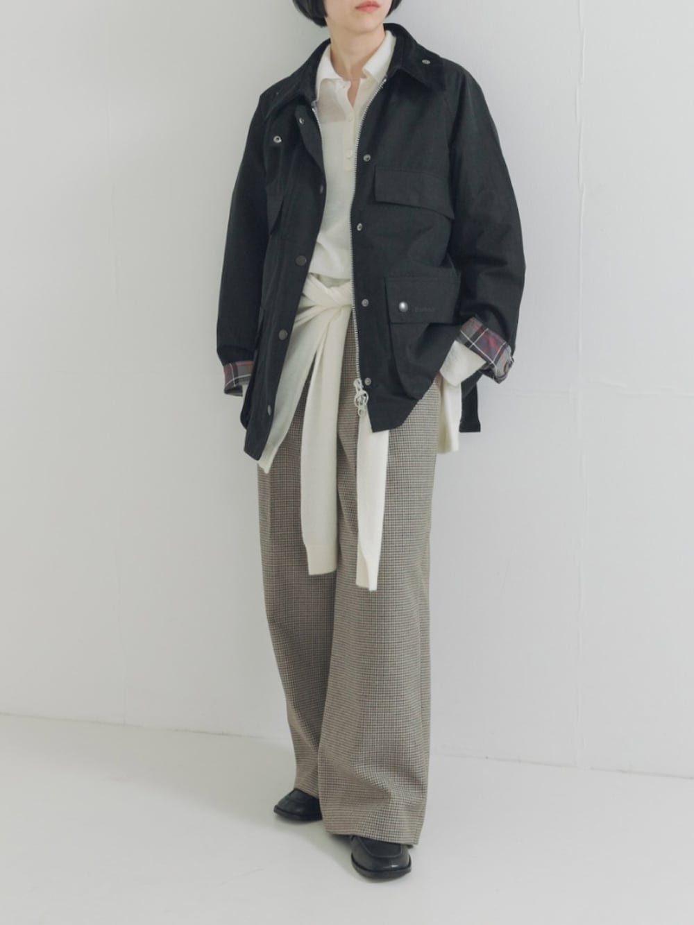 ブラック系のその他アウター、ホワイト系のニット/セーター、グリーン系のその他パンツを着用したレディースの秋コーディネートの2枚目の写真