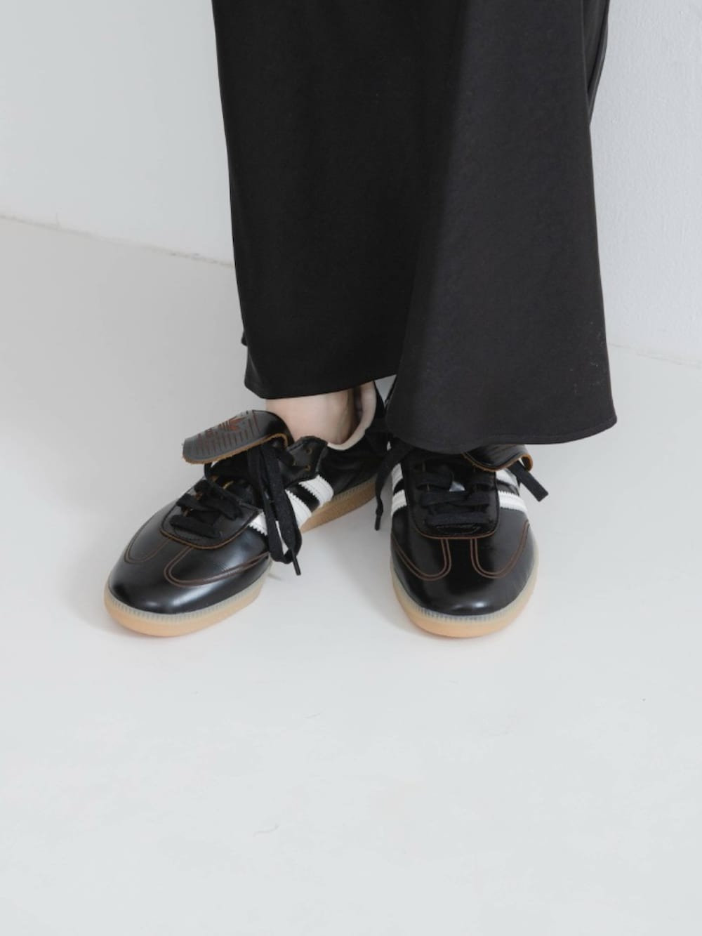 グレー系のスウェット、ブラック系のスカート、ブラック系のスニーカーを着用したレディースの冬コーディネートの4枚目の写真