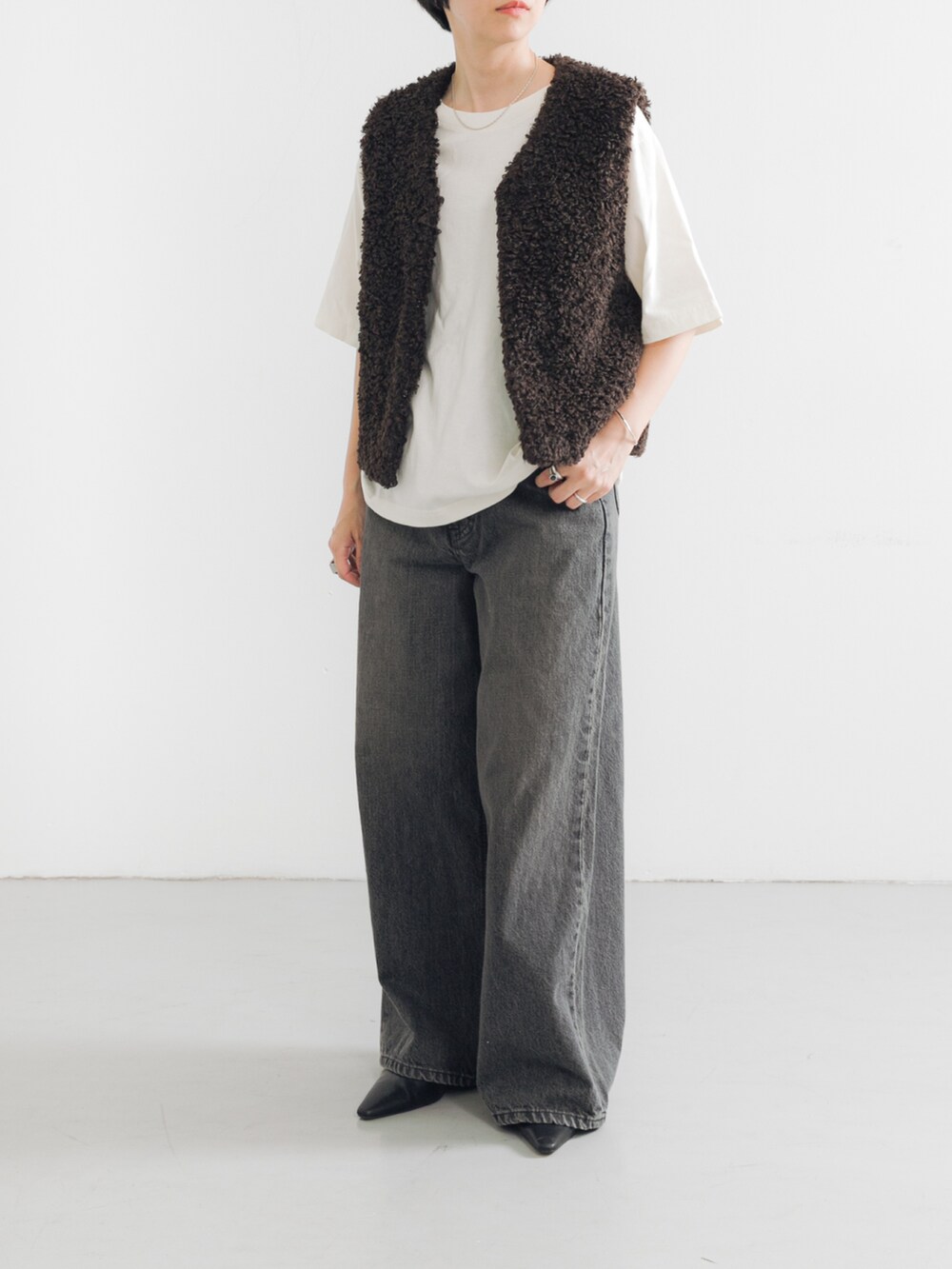 ホワイト系のTシャツ/カットソー、ブラック系のパンプス、ブラウン系のベストを着用したレディースの夏コーディネートの2枚目の写真