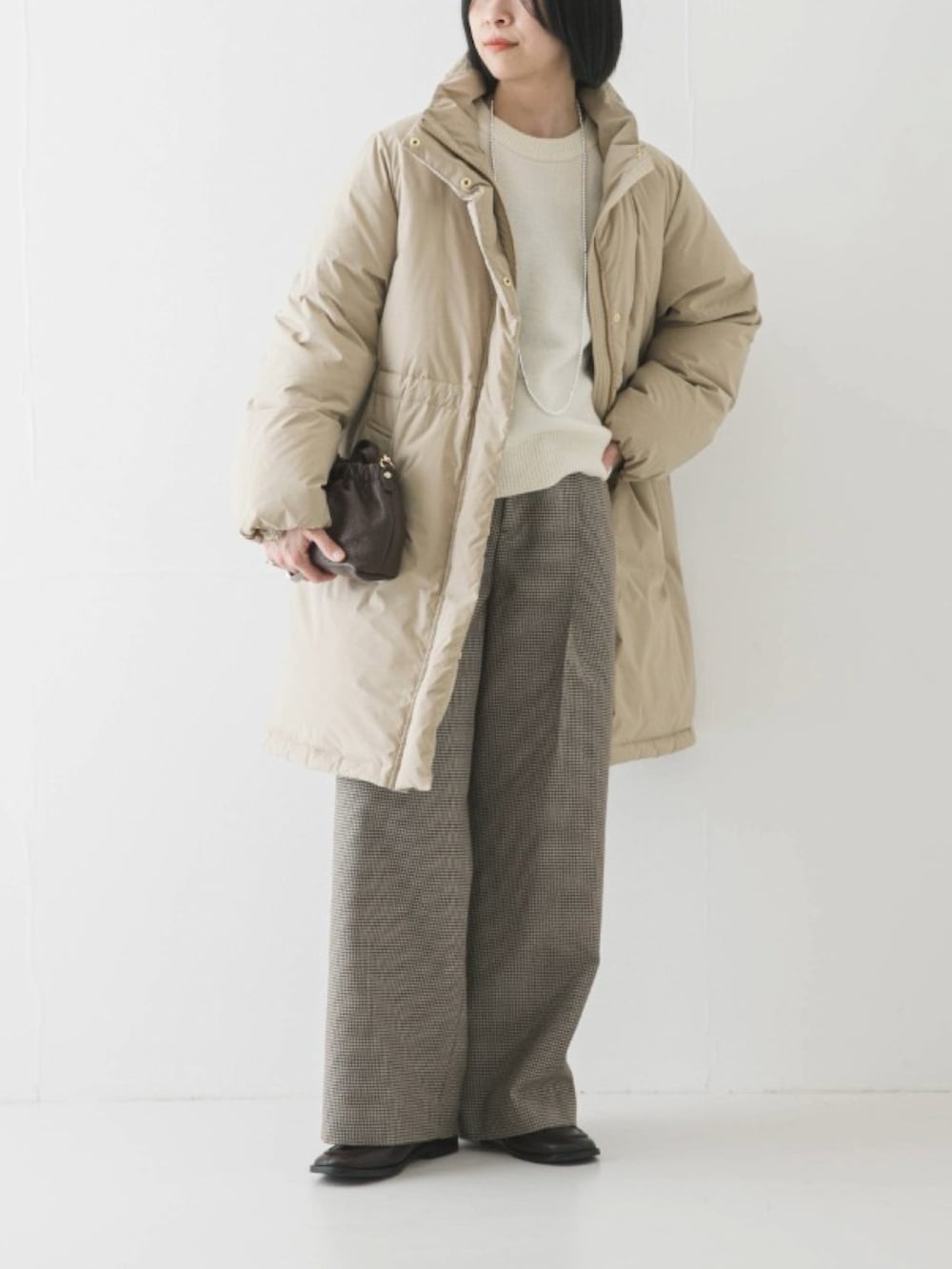 ベージュ系のダウンジャケット/コート、ホワイト系のニット/セーター、グリーン系のその他パンツを着用したレディースの冬コーディネートの3枚目の写真