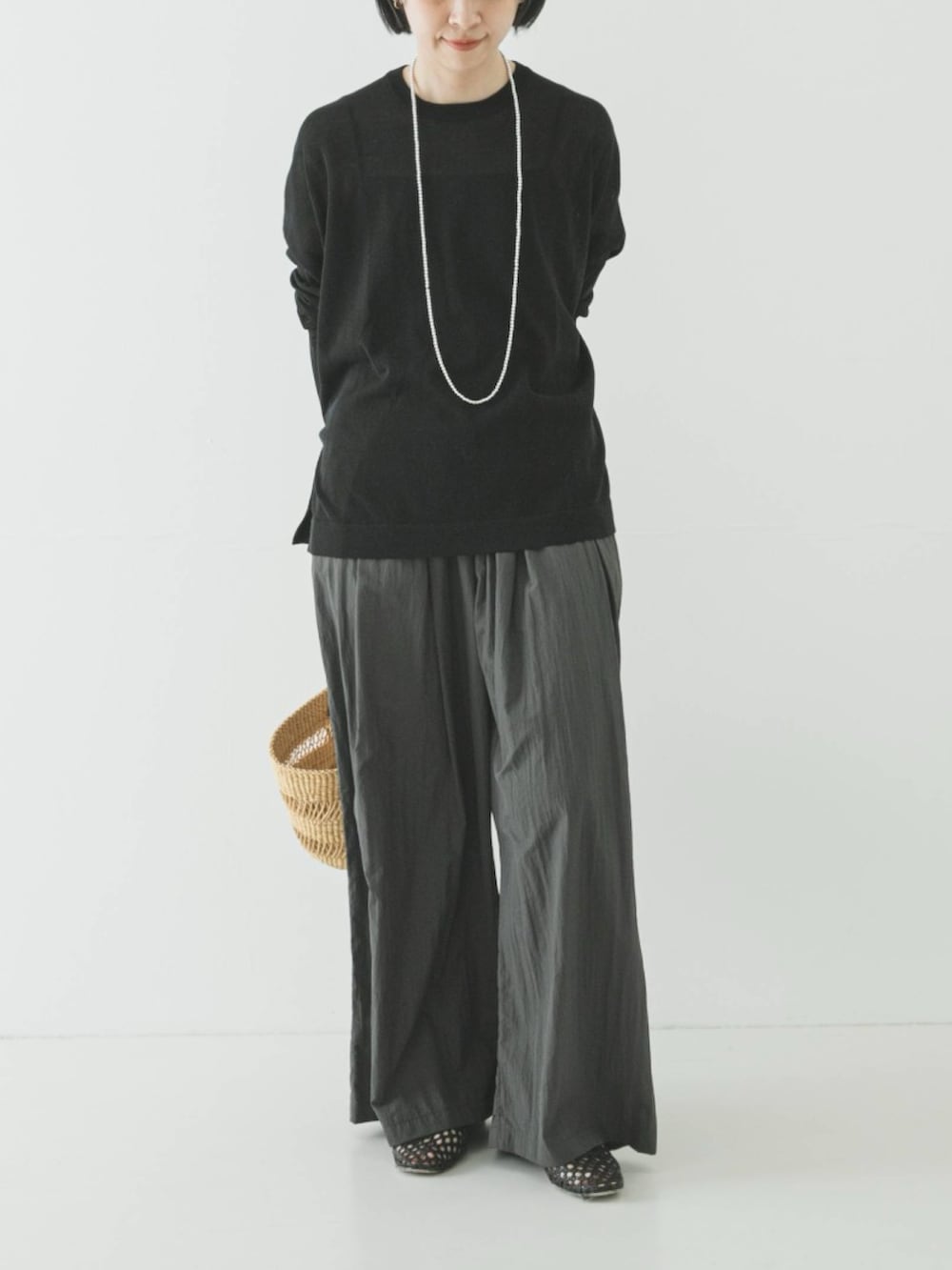 ブラック系のニット/セーター、グレー系のその他パンツ、ブラック系のパンプスを着用したレディースの春コーディネートの2枚目の写真