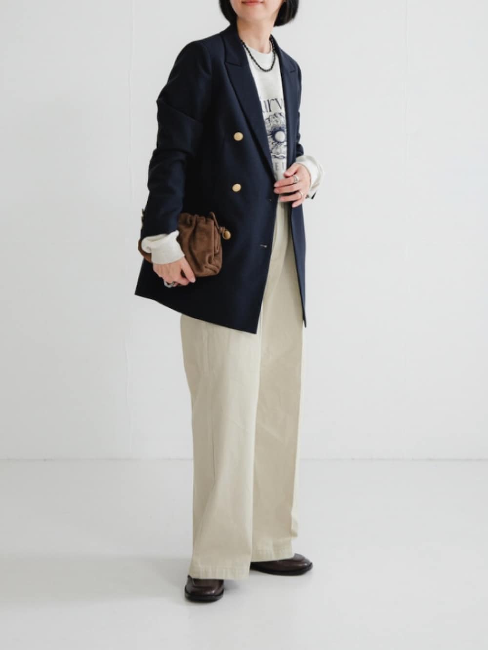 ベージュ系のスウェット、ブルー系のその他アウター、ブラウン系のローファーを着用したレディースの冬コーディネートの2枚目の写真