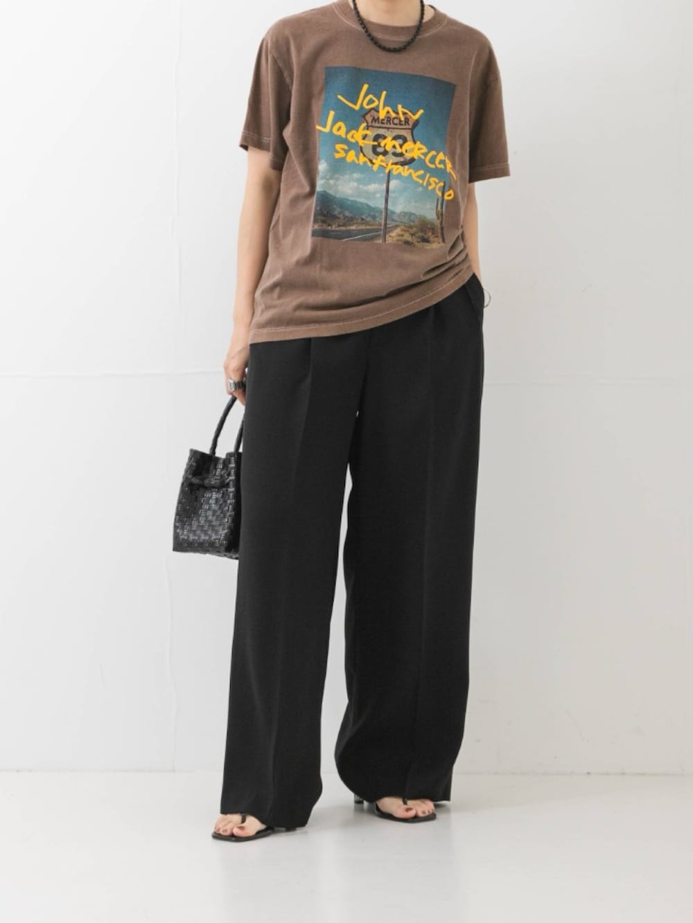 ブラウン系のTシャツ/カットソー、ブラック系のその他パンツ、ブラック系のトートバッグを着用したレディースの夏コーディネートの2枚目の写真