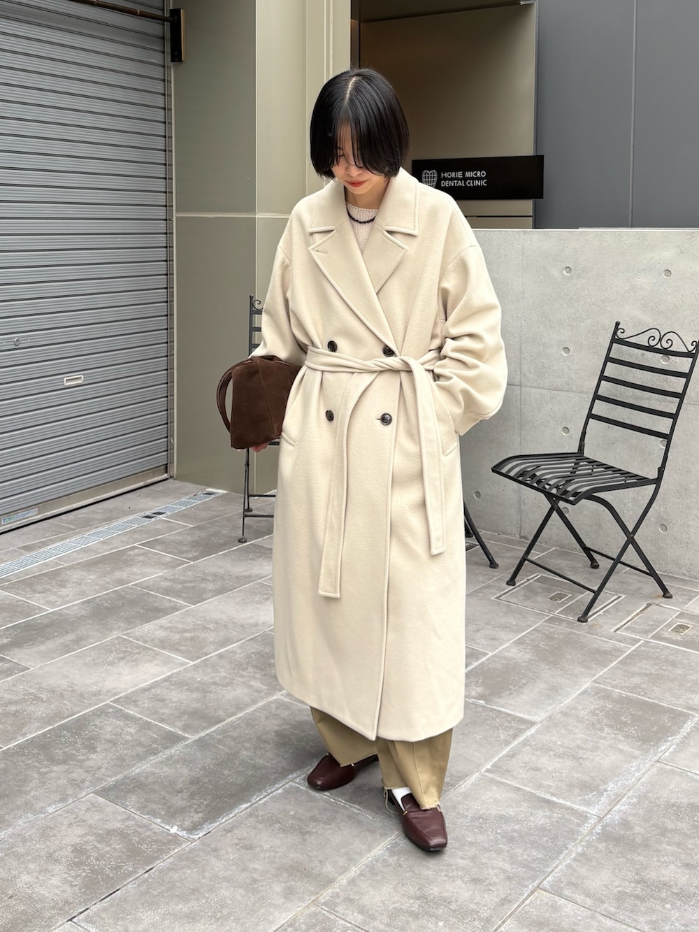 ベージュ系のその他パンツ、ベージュ系のチェスターコート、ホワイト系のニット/セーターを着用したレディースの秋コーディネートの3枚目の写真