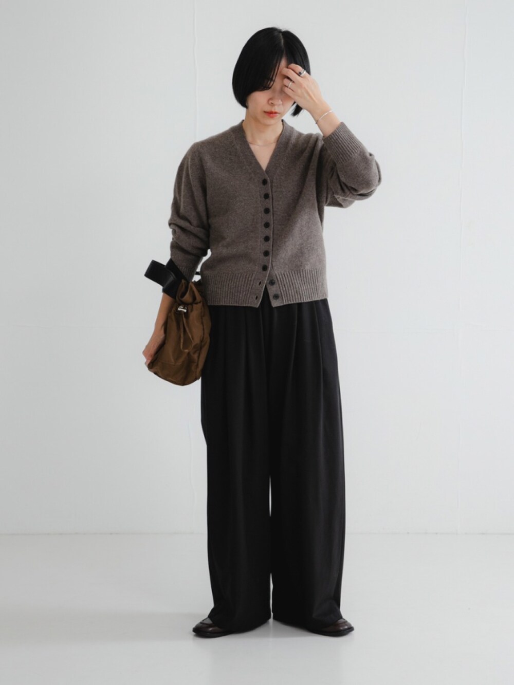 ブラウン系のカーディガン/ボレロ、ブラック系のその他パンツ、ブラウン系のショルダーバッグを着用したレディースの秋コーディネートの3枚目の写真