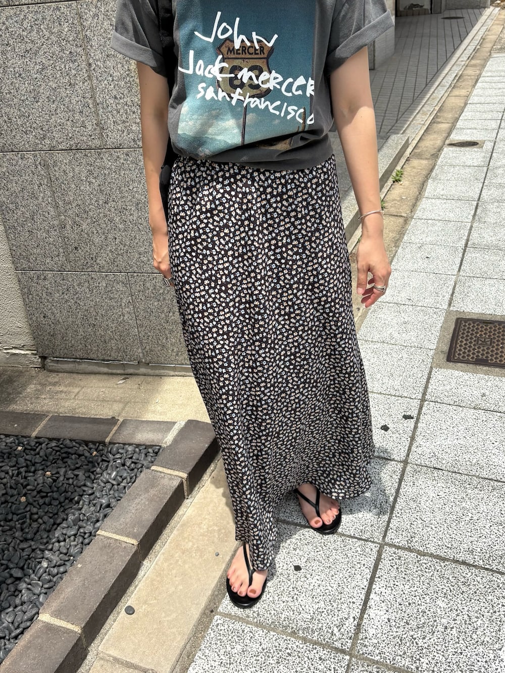 グレー系のTシャツ/カットソー、ホワイト系のスカート、ブラック系のバックパック/リュックを着用したレディースの夏コーディネートの3枚目の写真