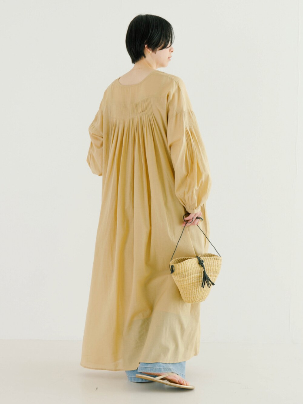 ベージュ系のワンピースを着用したレディースの春コーディネートの2枚目の写真