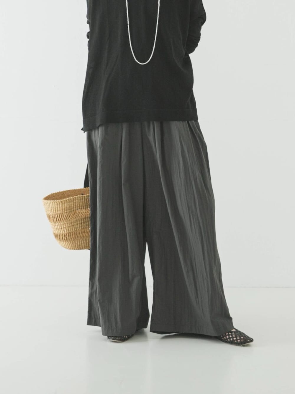 ブラック系のニット/セーター、グレー系のその他パンツ、ブラック系のパンプスを着用したレディースの春コーディネートの3枚目の写真