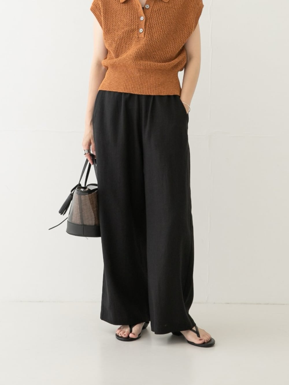 ブラウン系のニット/セーター、ブラック系のその他パンツ、ブラック系のかごバッグを着用したレディースの夏コーディネートの2枚目の写真