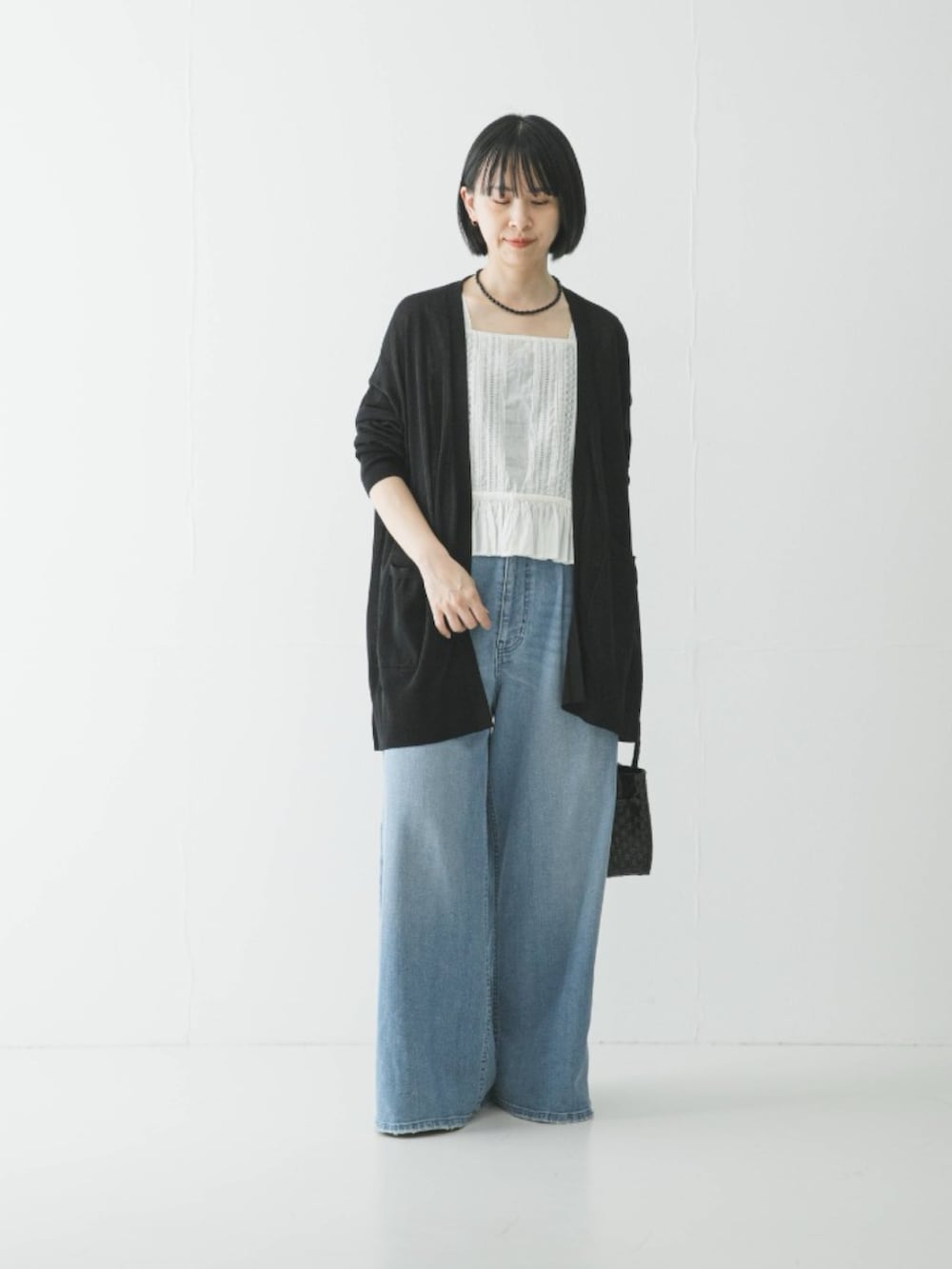 ホワイト系のシャツ/ブラウス、ブルー系のデニムパンツ、ブラック系のカーディガン/ボレロを着用したレディースの夏コーディネートの4枚目の写真