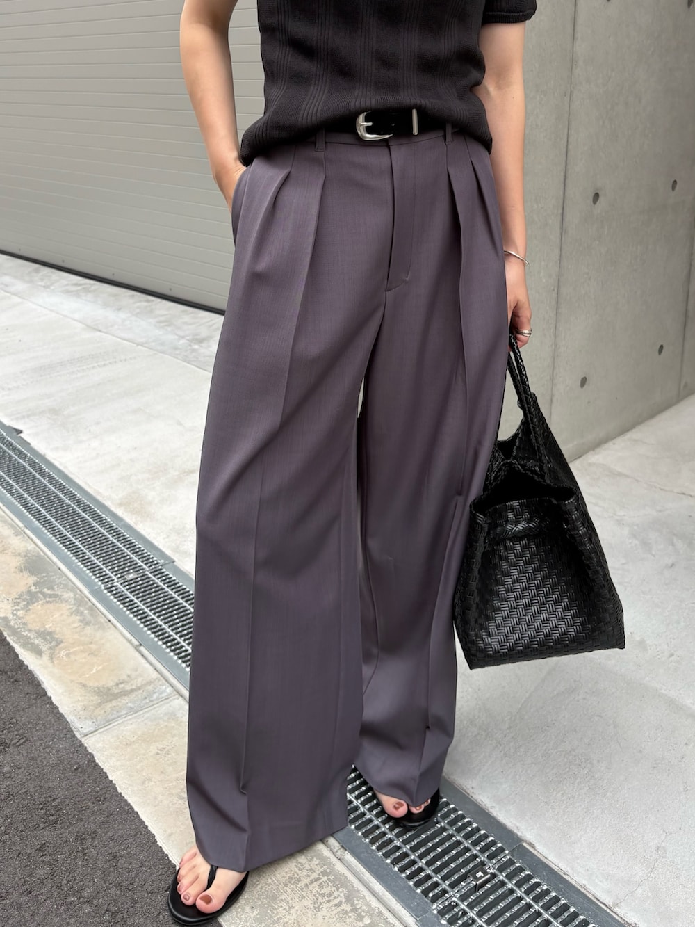 グレー系のニット/セーター、グレー系のその他パンツ、ブラック系のトートバッグを着用したレディースの夏コーディネートの3枚目の写真