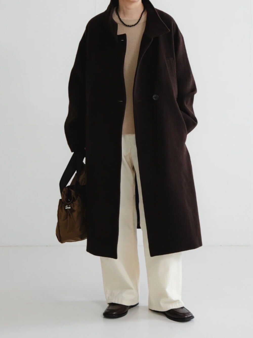 ブラウン系のその他アウター、ベージュ系のニット/セーター、ホワイト系のその他パンツを着用したレディースの冬コーディネートの2枚目の写真