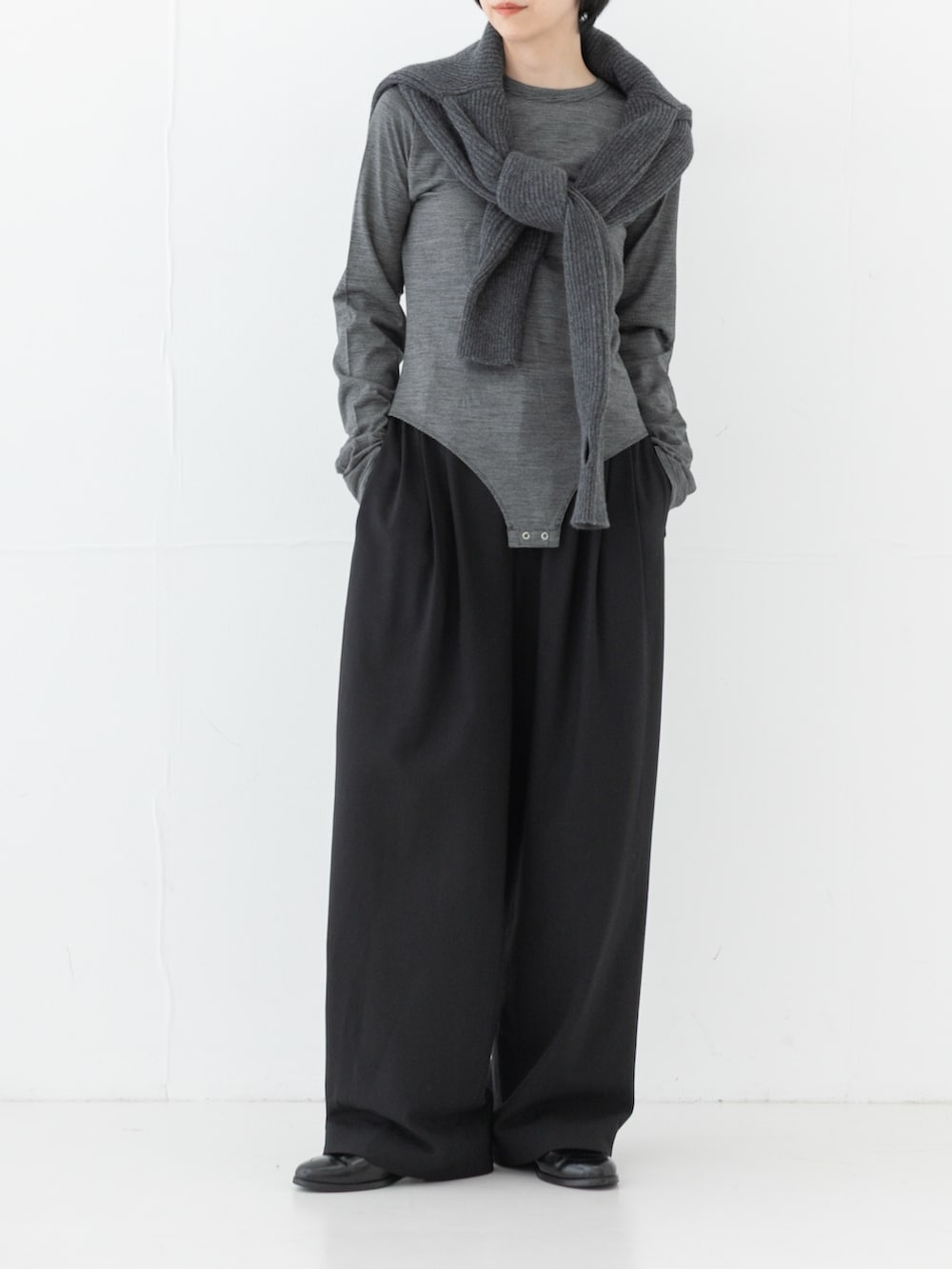 グレー系のニット/セーター、ブラック系のその他パンツ、ブラック系のTシャツ/カットソーを着用したレディースの秋コーディネートの2枚目の写真