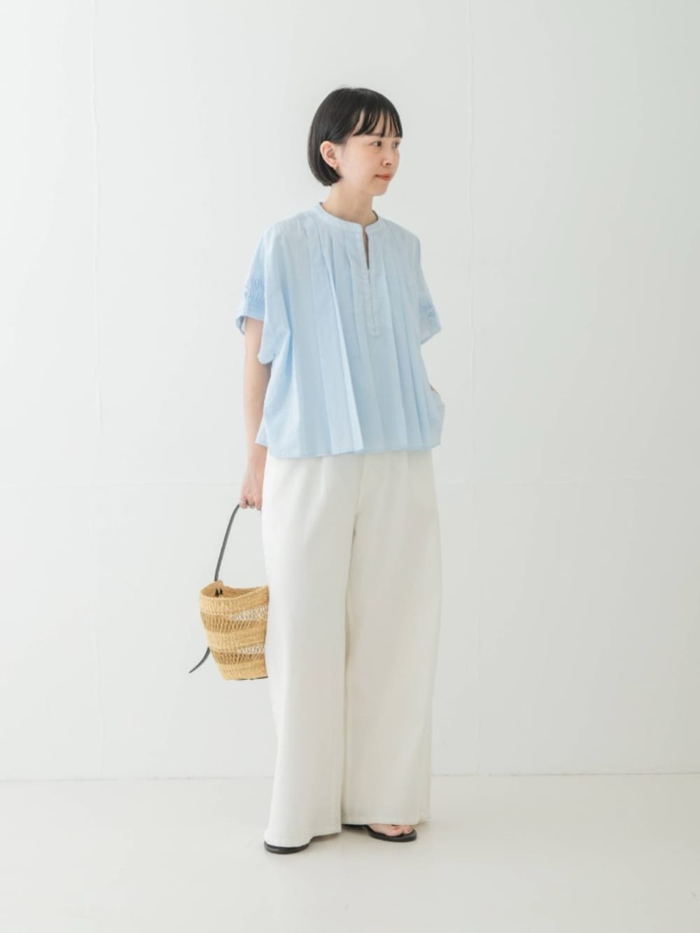 ブルー系のシャツ/ブラウス、ブラック系のサンダル、ベージュ系のかごバッグを着用したレディースの夏コーディネートの2枚目の写真