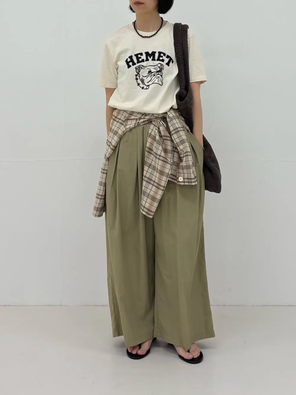 ベージュ系のTシャツ/カットソー、ベージュ系のその他パンツ、ブラウン系のトートバッグを着用したレディースの春コーディネートの3枚目の写真