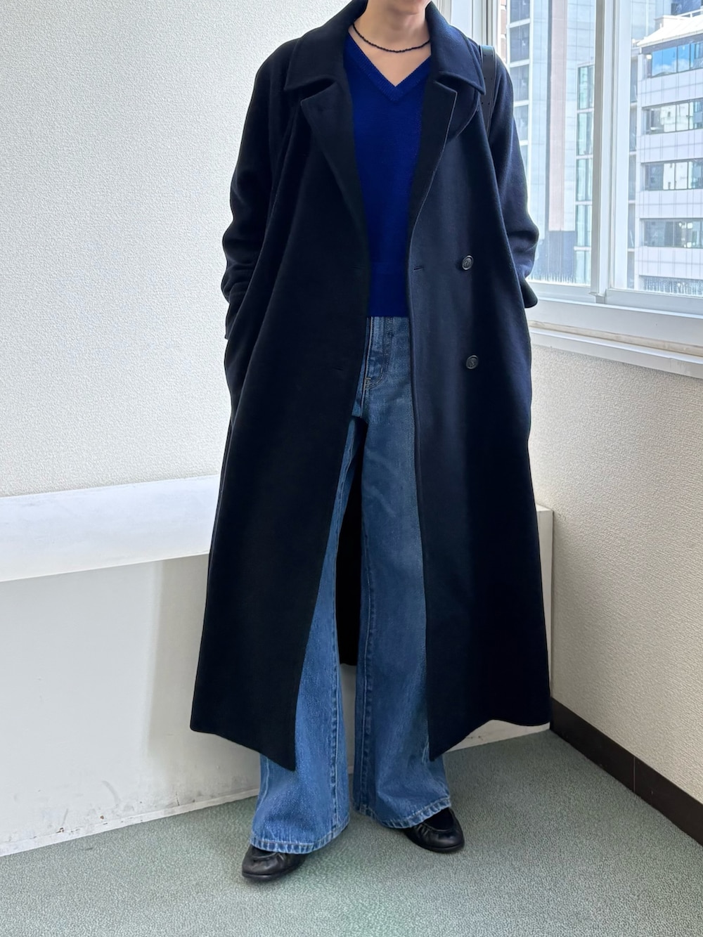 ブルー系のステンカラーコート、ブルー系のデニムパンツ、ブラック系のローファーを着用したレディースの秋コーディネートの2枚目の写真