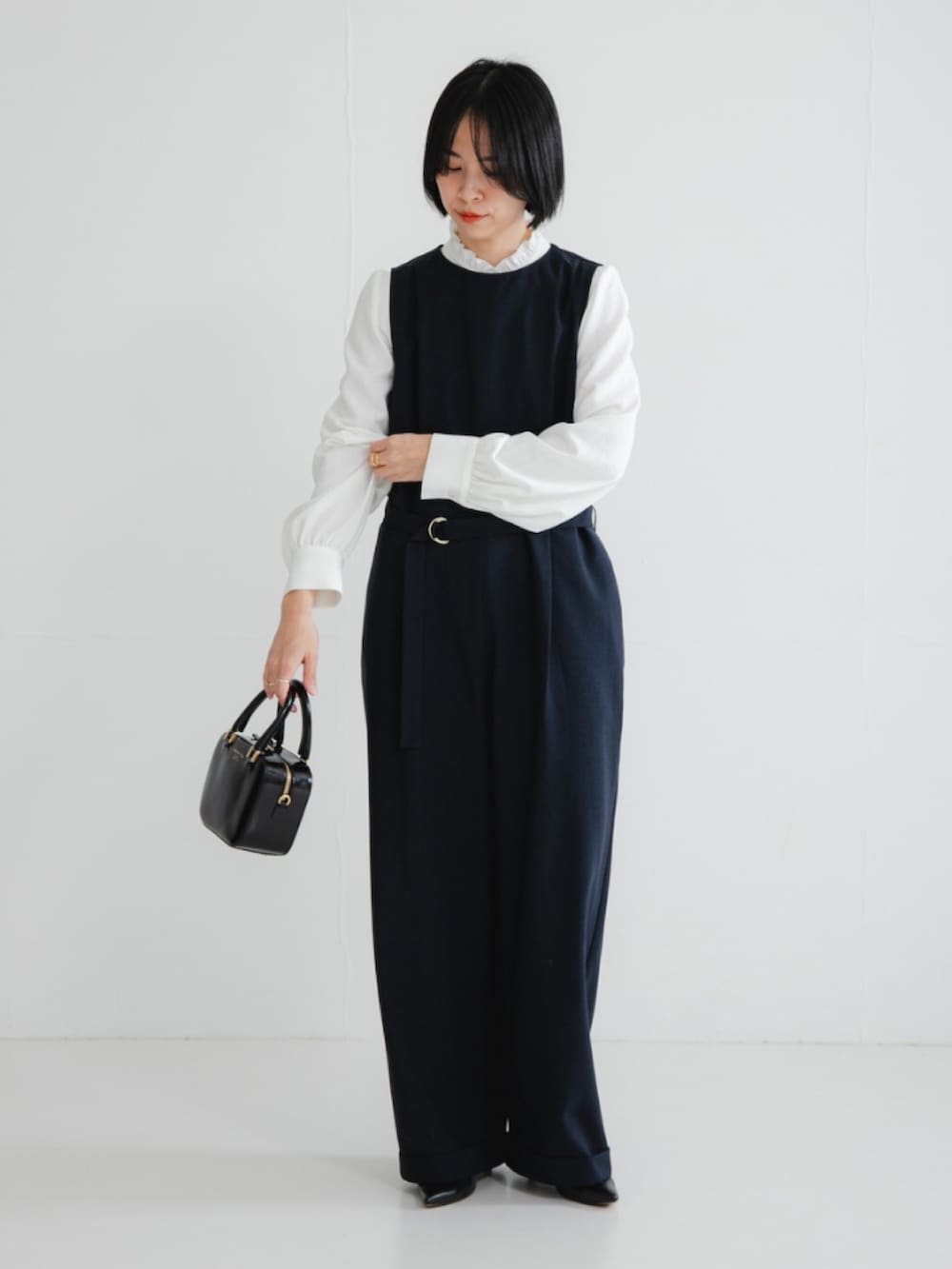 ブルー系のその他パンツ、ホワイト系のシャツ/ブラウス、ブラック系のショルダーバッグを着用したレディースの冬コーディネートの2枚目の写真