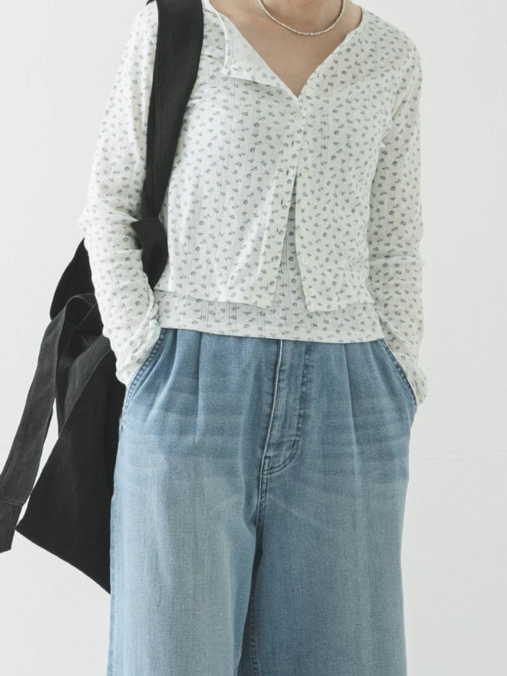 ブルー系のカーディガン/ボレロ、ブラック系のトートバッグ、ブルー系のデニムパンツを着用したレディースの春コーディネートの3枚目の写真