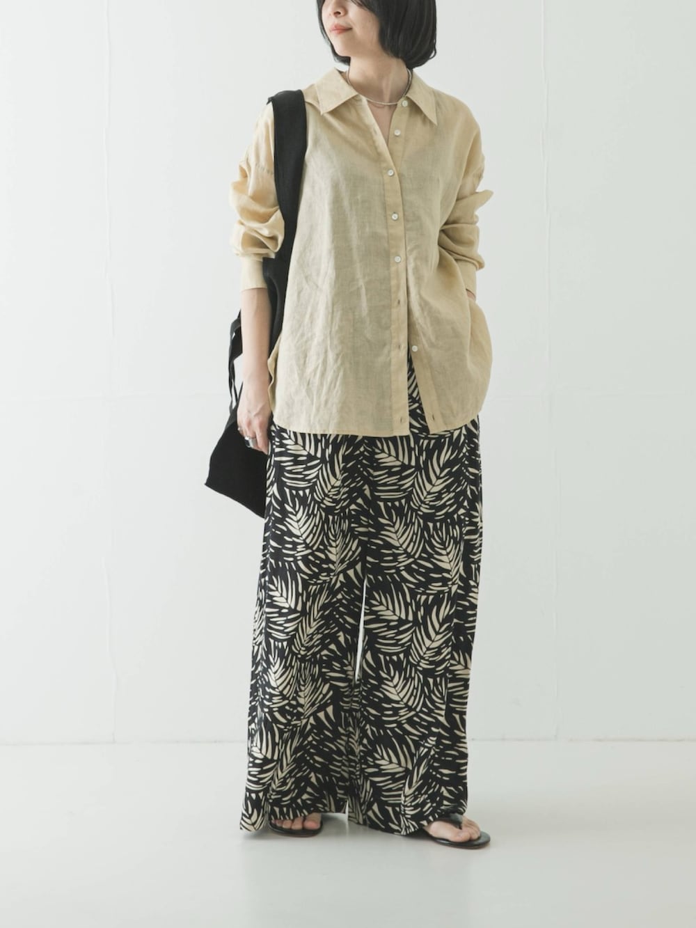 ベージュ系のシャツ/ブラウス、ブラック系のその他パンツ、ブラック系のトートバッグを着用したレディースの春コーディネートの2枚目の写真