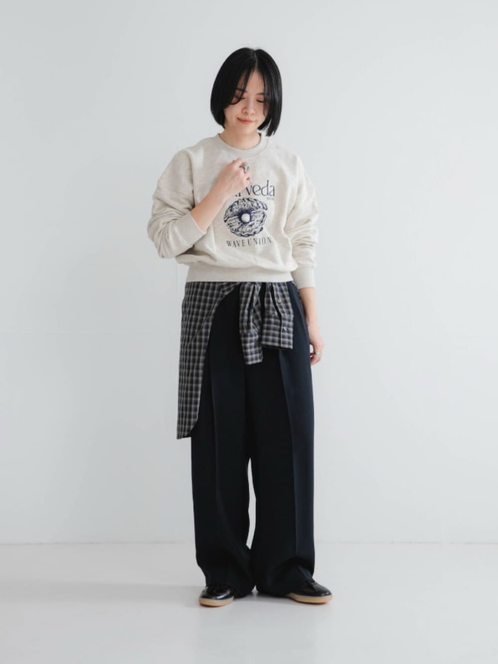 ベージュ系のスウェット、ブラック系のスニーカー、ブルー系のその他パンツを着用したレディースの冬コーディネートの2枚目の写真