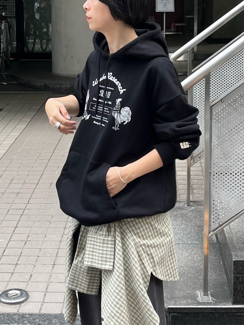 グレー系のスカート、グリーン系のシャツ/ブラウス、ブラック系のスウェットを着用したレディースの秋コーディネートの2枚目の写真