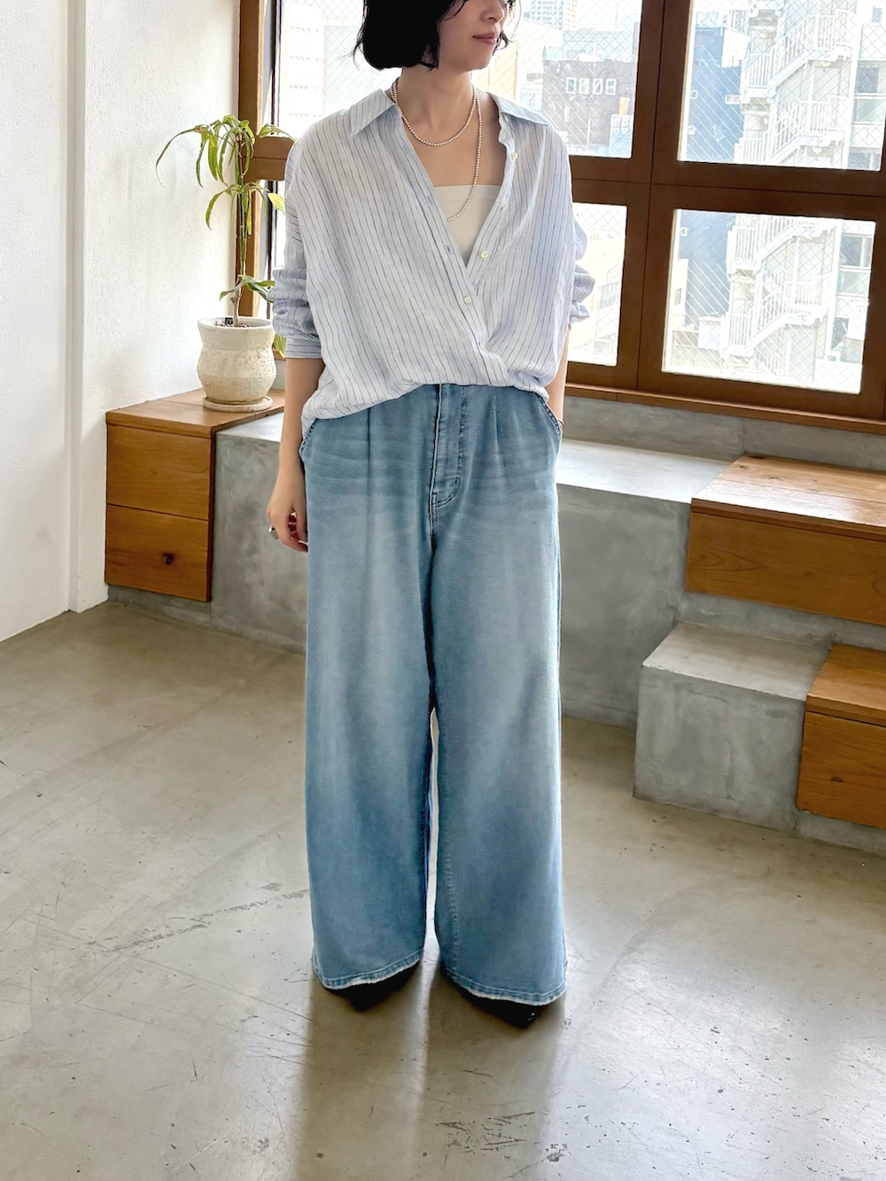 ブルー系のシャツ/ブラウス、ブルー系のデニムパンツ、ブラック系のパンプスを着用したレディースの冬コーディネートの2枚目の写真