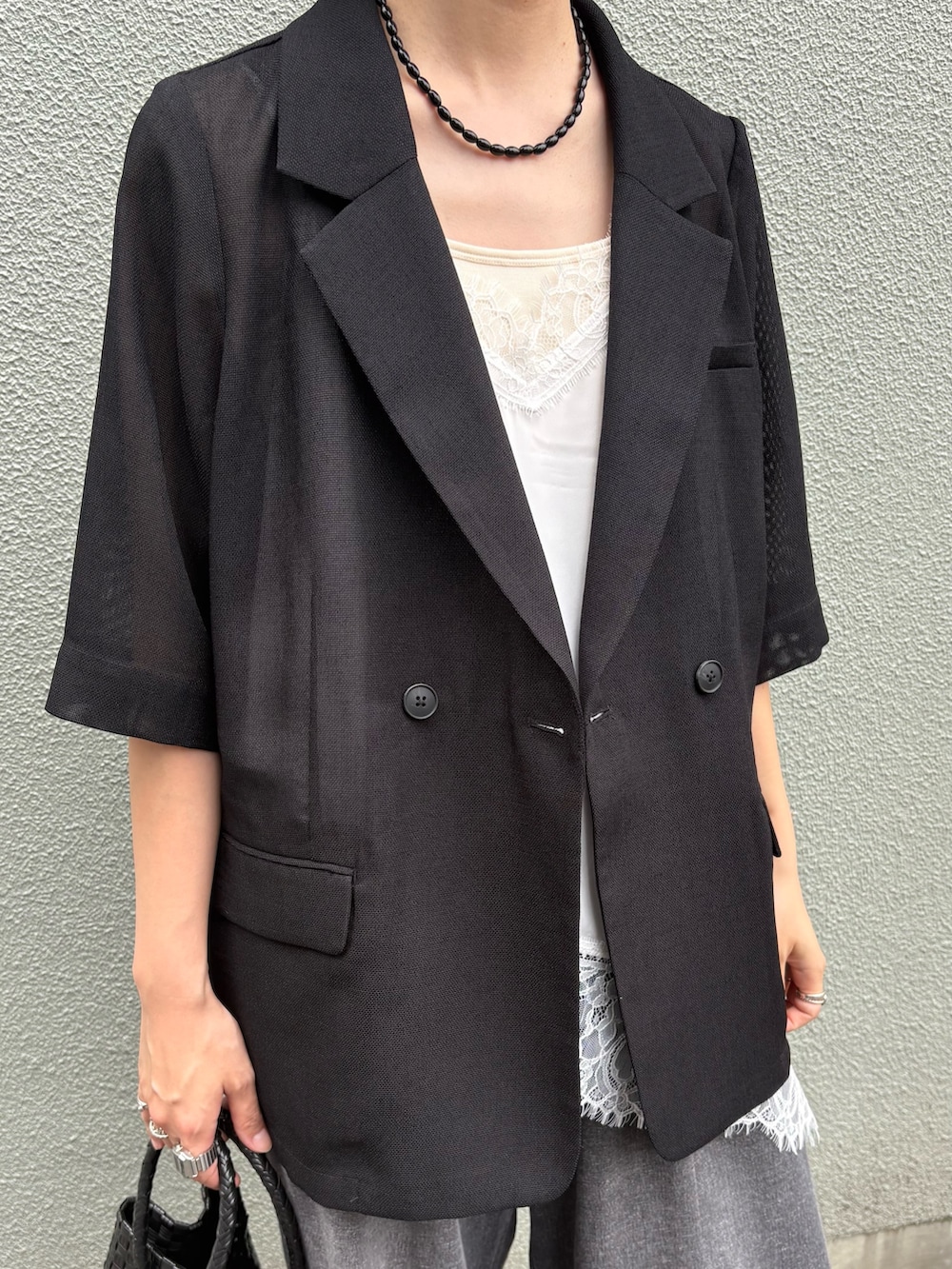 ブラック系のデニムパンツ、ブラック系のトートバッグ、ブラック系のその他アウターを着用したレディースの夏コーディネートの3枚目の写真