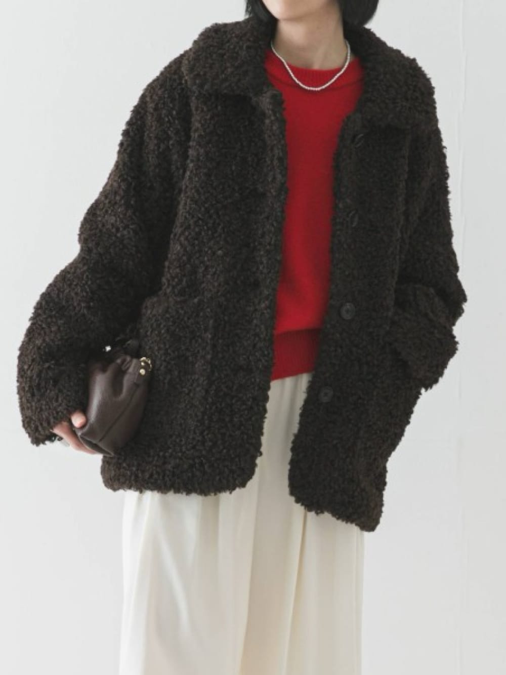 ブラウン系のその他アウター、レッド系のニット/セーター、ホワイト系のその他パンツを着用したレディースの冬コーディネートの3枚目の写真