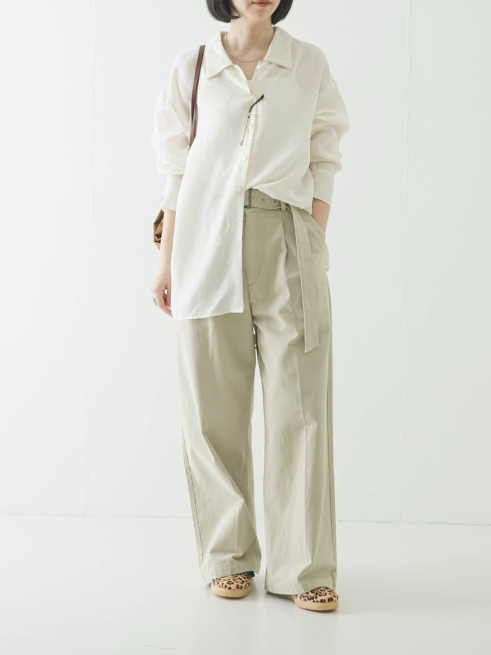 ホワイト系のシャツ/ブラウス、ブラウン系のバックパック/リュック、ベージュ系のその他パンツを着用したレディースの春コーディネートの2枚目の写真