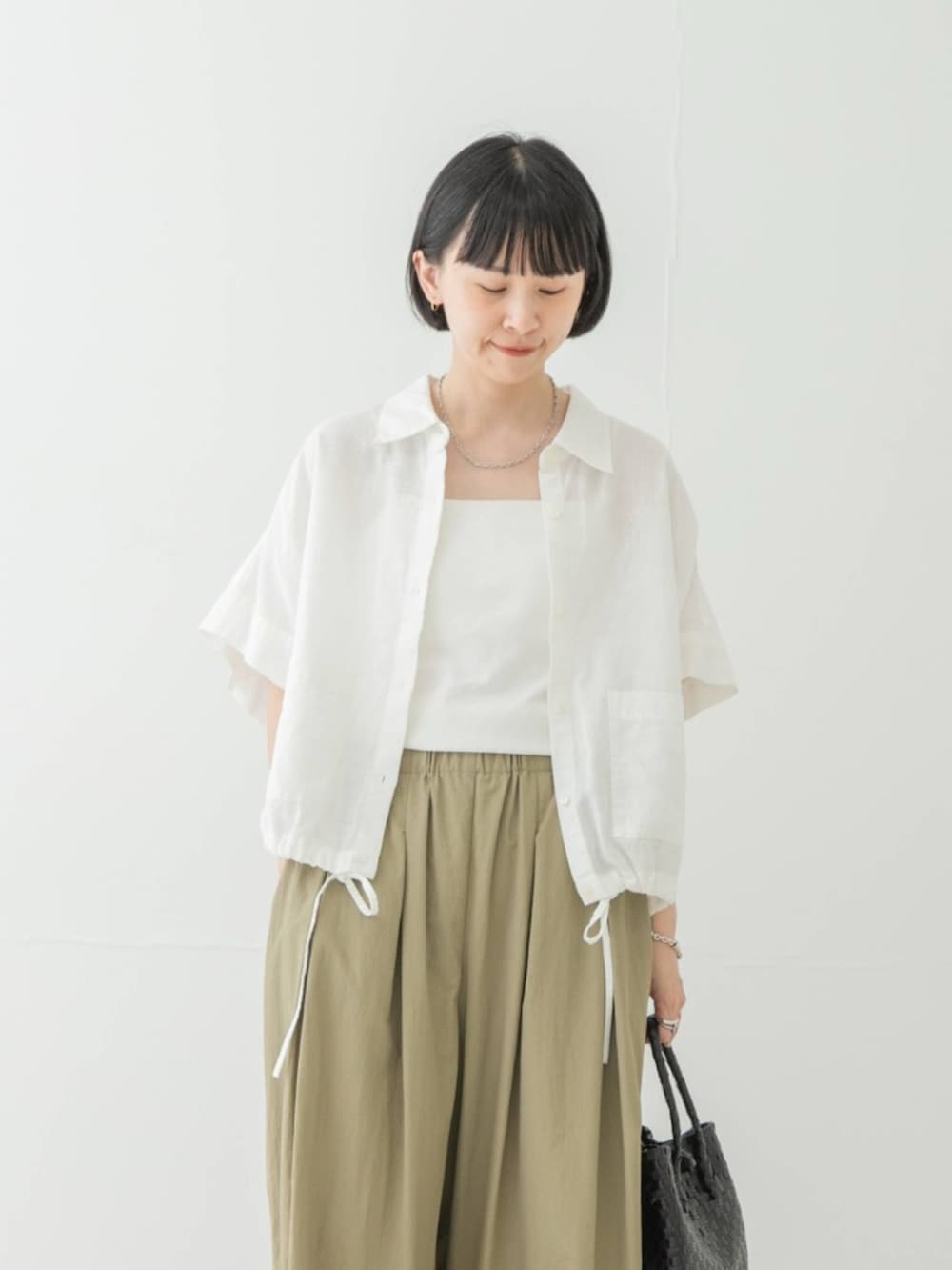 ホワイト系のシャツ/ブラウス、ベージュ系のその他パンツ、ブラック系のトートバッグを着用したレディースの夏コーディネートの2枚目の写真
