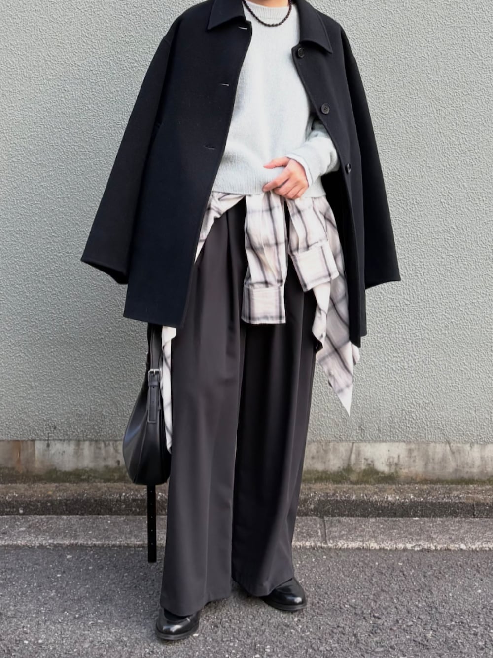 ブラック系のその他パンツ、グリーン系のニット/セーター、ブラック系のステンカラーコートを着用したレディースの秋コーディネートの3枚目の写真