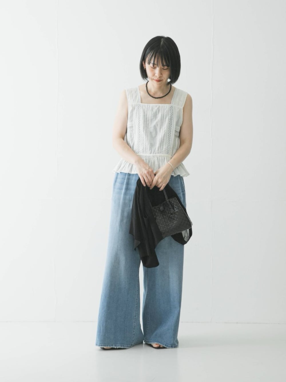 ホワイト系のシャツ/ブラウス、ブルー系のデニムパンツ、ブラック系のカーディガン/ボレロを着用したレディースの夏コーディネートの2枚目の写真