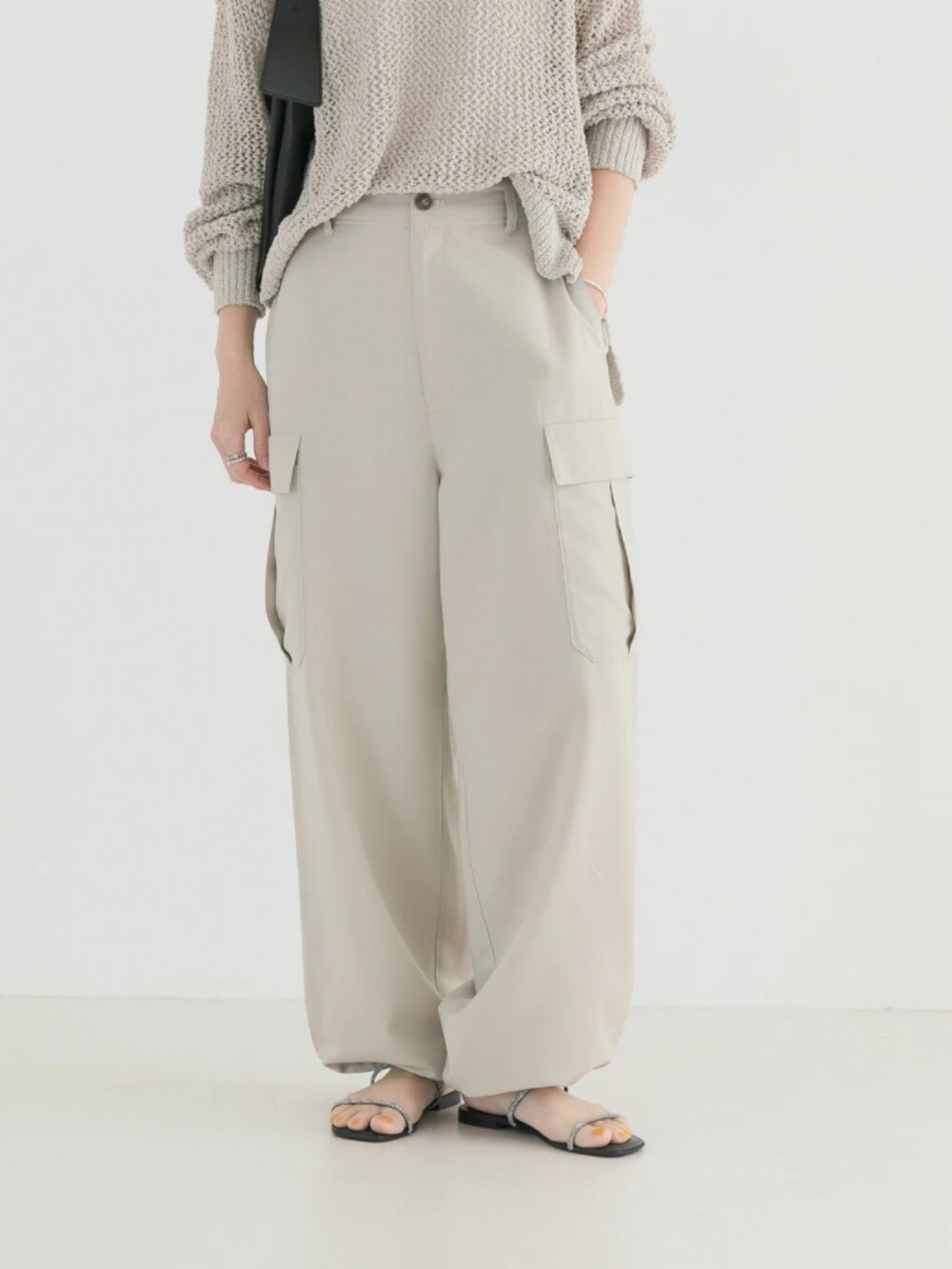 ホワイト系のニット/セーター、ベージュ系のカーゴパンツを着用したレディースの春コーディネートの5枚目の写真