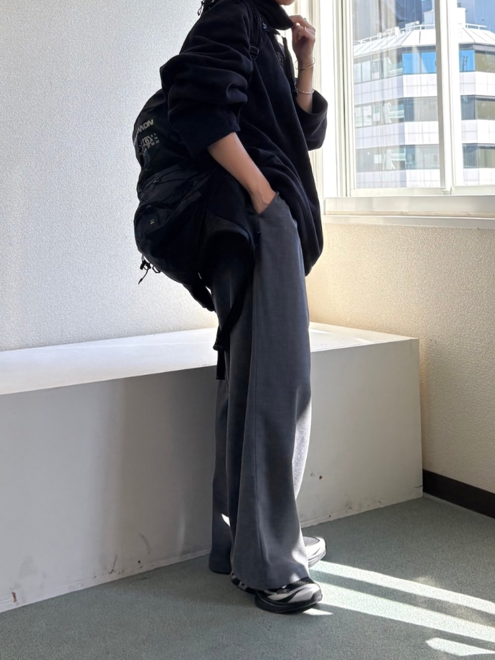 グレー系のその他パンツ、ブラック系のバックパック/リュック、ブラック系のスニーカーを着用したレディースの秋コーディネートの2枚目の写真