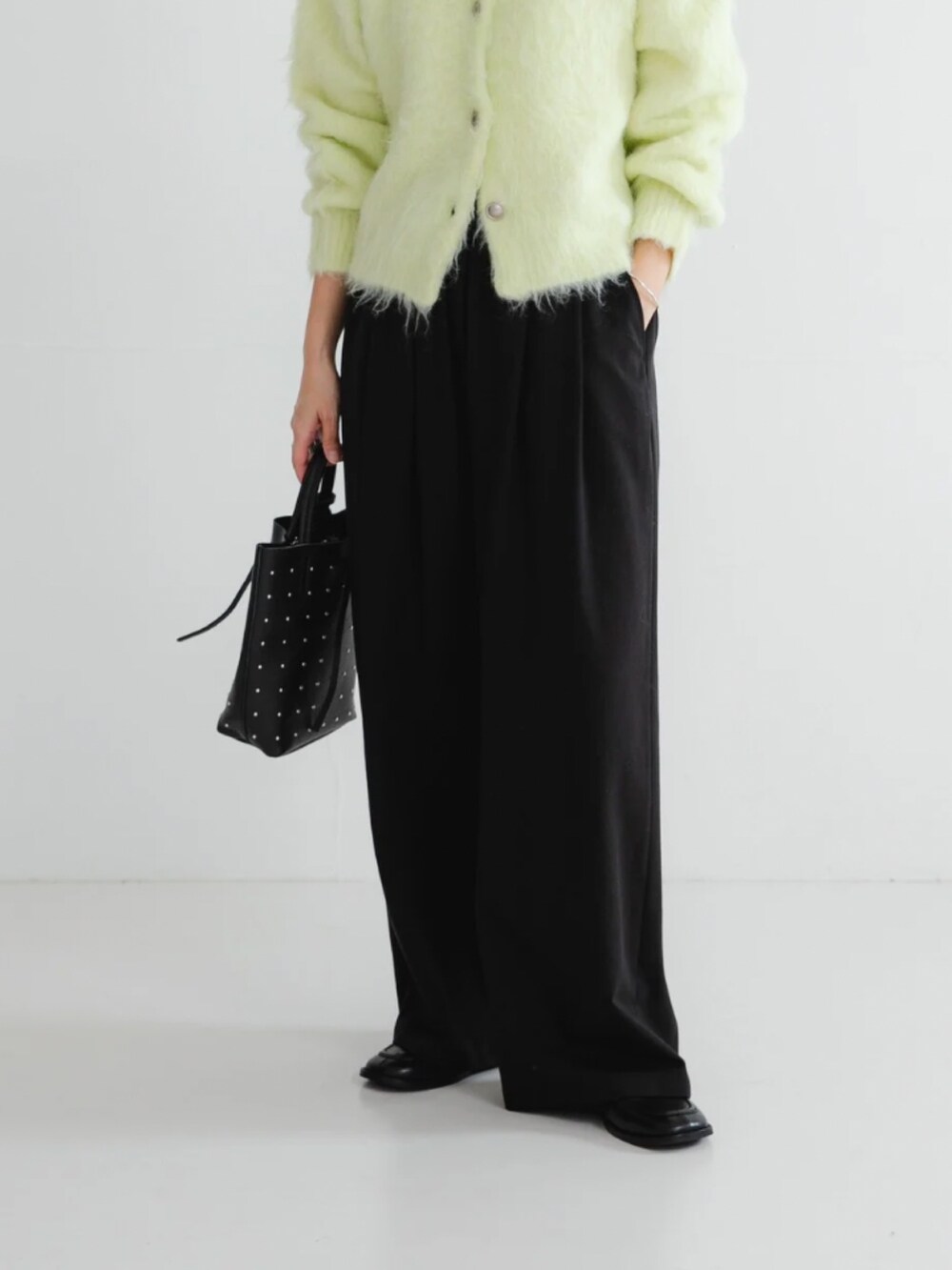 グリーン系のカーディガン/ボレロ、ブラック系のトートバッグ、ブラック系のその他パンツを着用したレディースの秋コーディネートの3枚目の写真