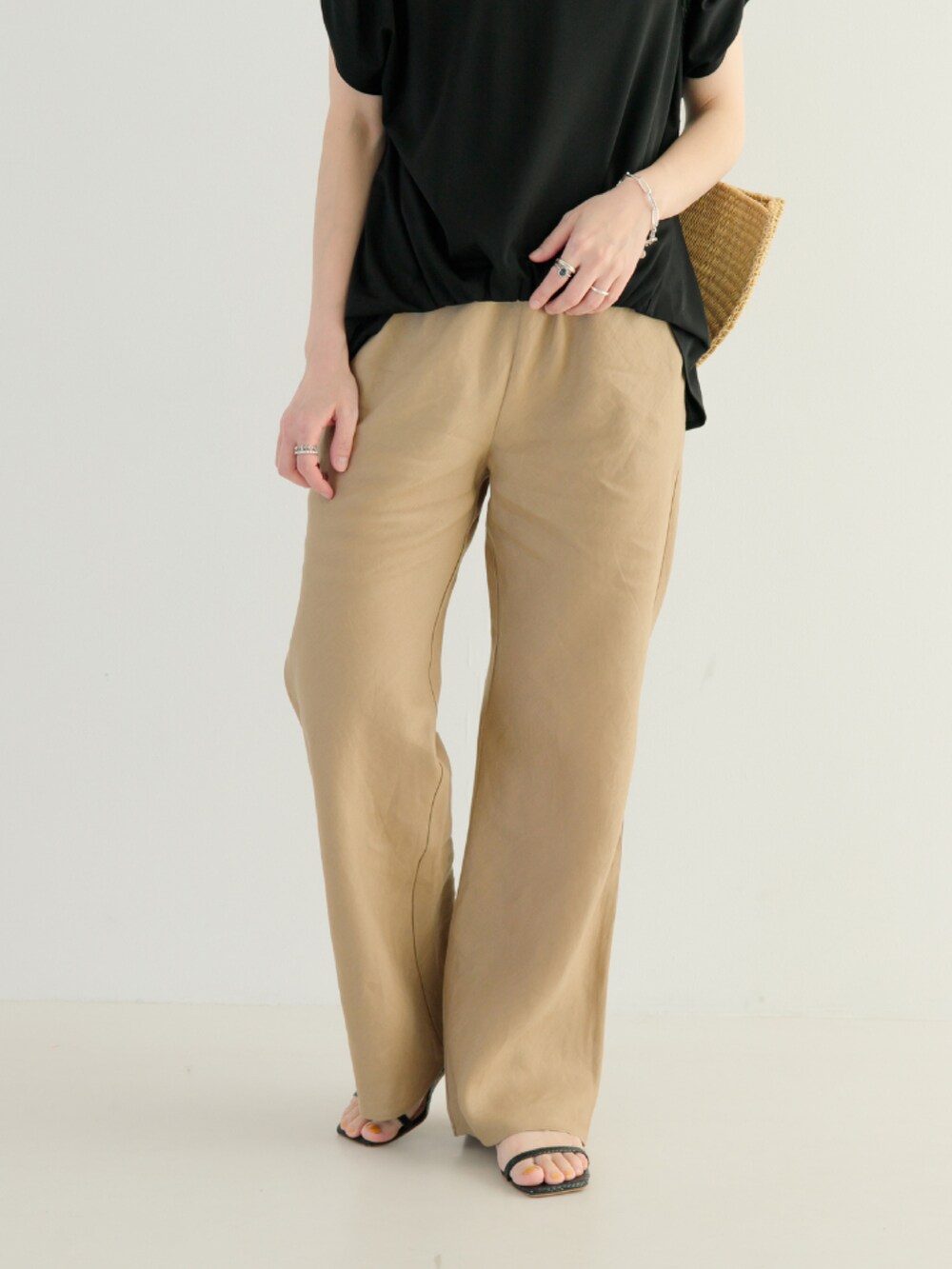 ブラック系のTシャツ/カットソー、ベージュ系のその他パンツ、ブラック系のハンドバッグを着用したレディースの春コーディネートの4枚目の写真