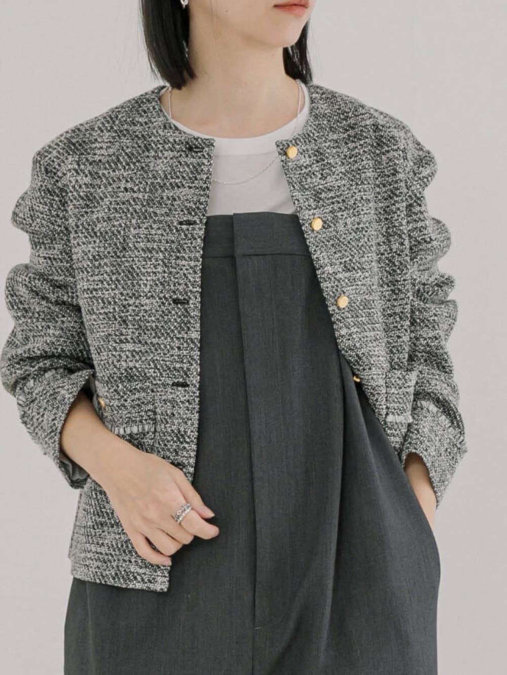 ブラック系のノーカラージャケット、グレー系のサロペット/オーバーオールを着用したレディースの冬コーディネートの2枚目の写真