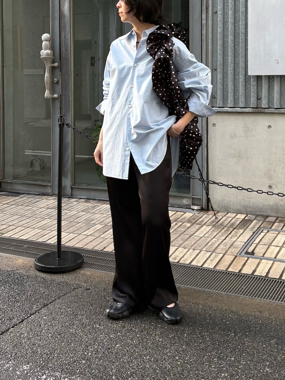 ブルー系のシャツ/ブラウス、ブラック系のその他パンツ、ブラック系のスニーカーを着用したレディースの春コーディネートの2枚目の写真