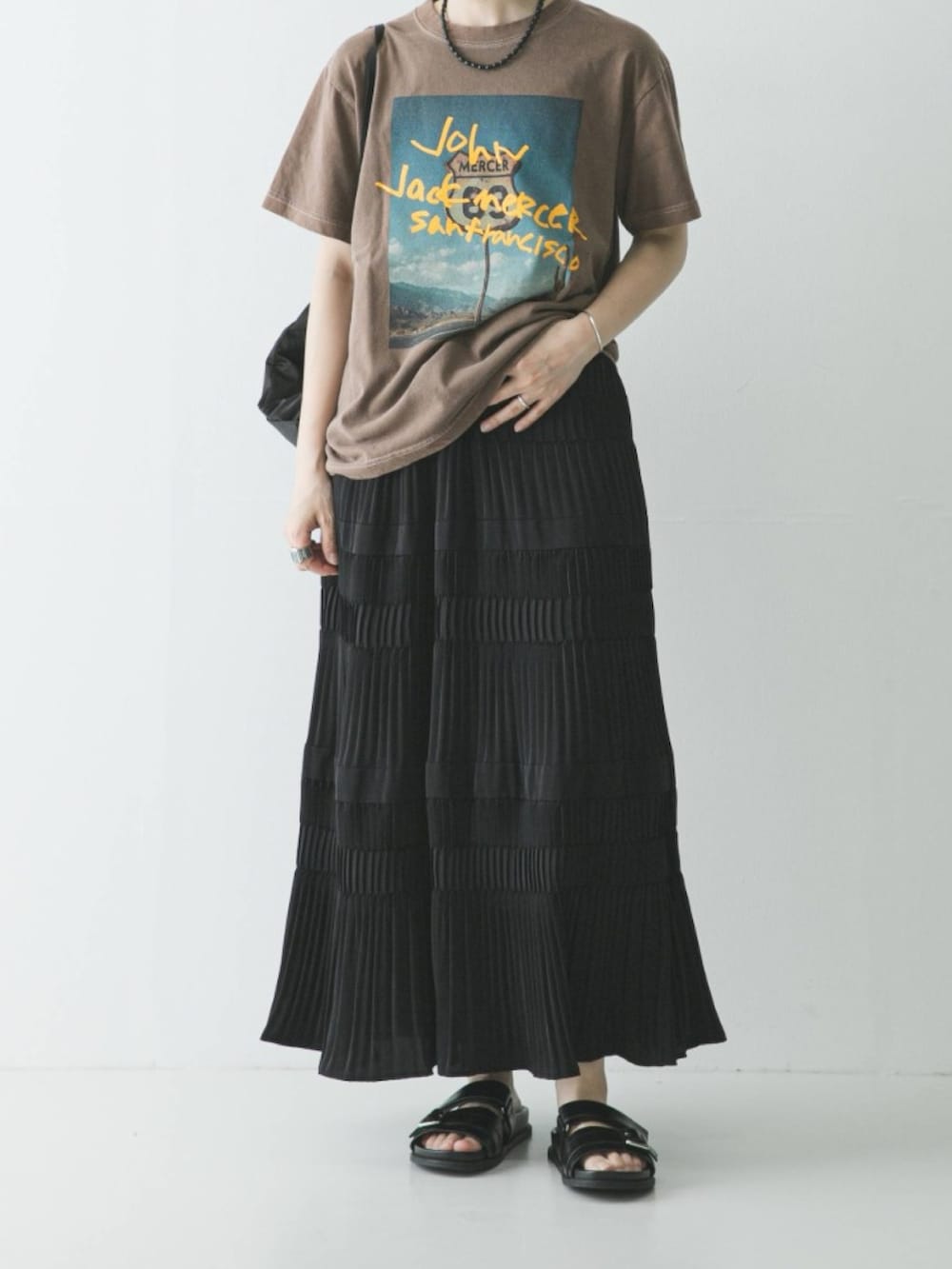 ブラック系のスカート、ブラック系のサンダル、ブラック系のバックパック/リュックを着用したレディースの春コーディネートの3枚目の写真