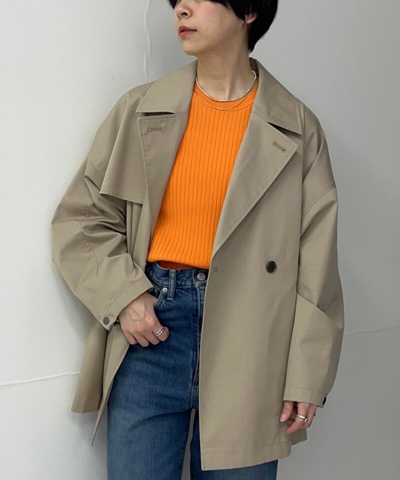 ベージュ系のトレンチコート、オレンジ系のニット/セーターを着用したレディースの春コーディネートの3枚目の写真