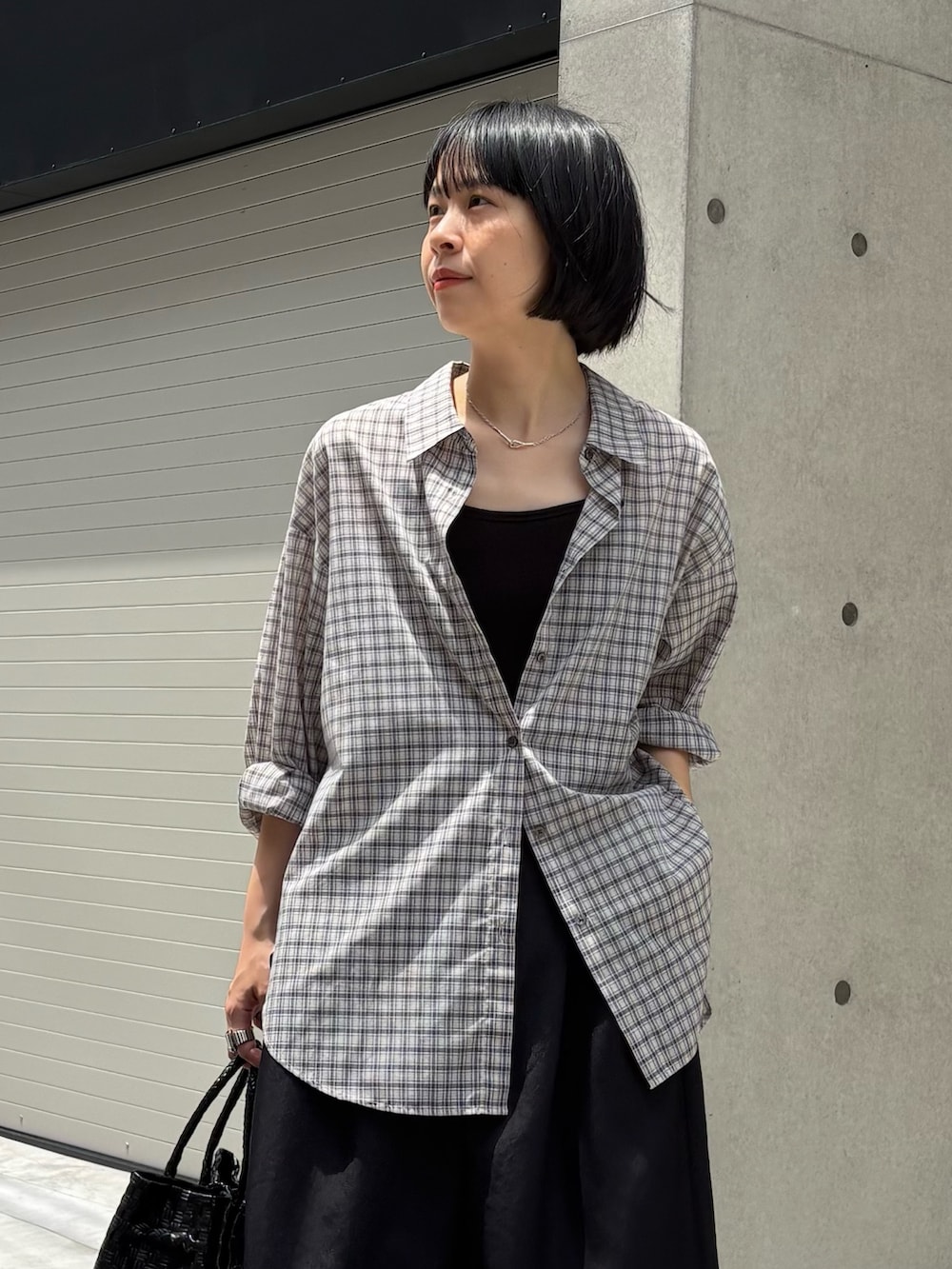 ベージュ系のシャツ/ブラウス、ブラック系のサンダル、ブラック系のトートバッグを着用したレディースの夏コーディネートの2枚目の写真