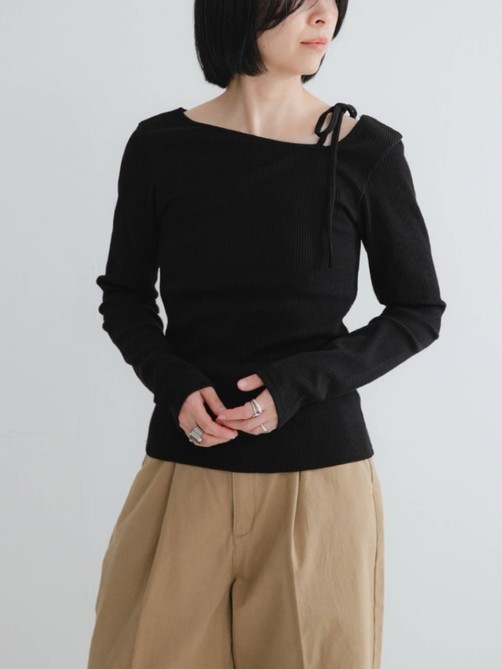 ブラック系のTシャツ/カットソー、ブラック系のパンプス、ベージュ系のその他パンツを着用したレディースの冬コーディネートの2枚目の写真