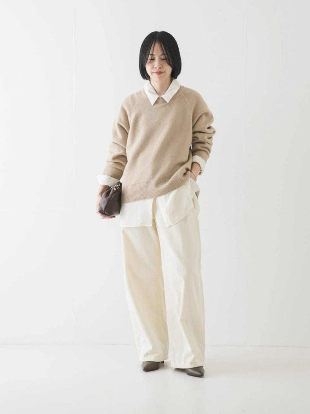 ベージュ系のニット/セーター、ホワイト系のその他パンツを着用したレディースの冬コーディネートの2枚目の写真