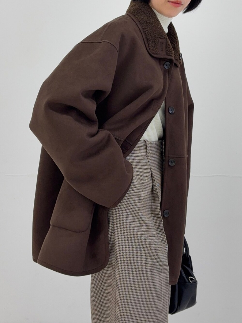 ホワイト系のニット/セーター、ブラウン系のムートンコート、ベージュ系のスニーカーを着用したレディースの秋コーディネートの3枚目の写真