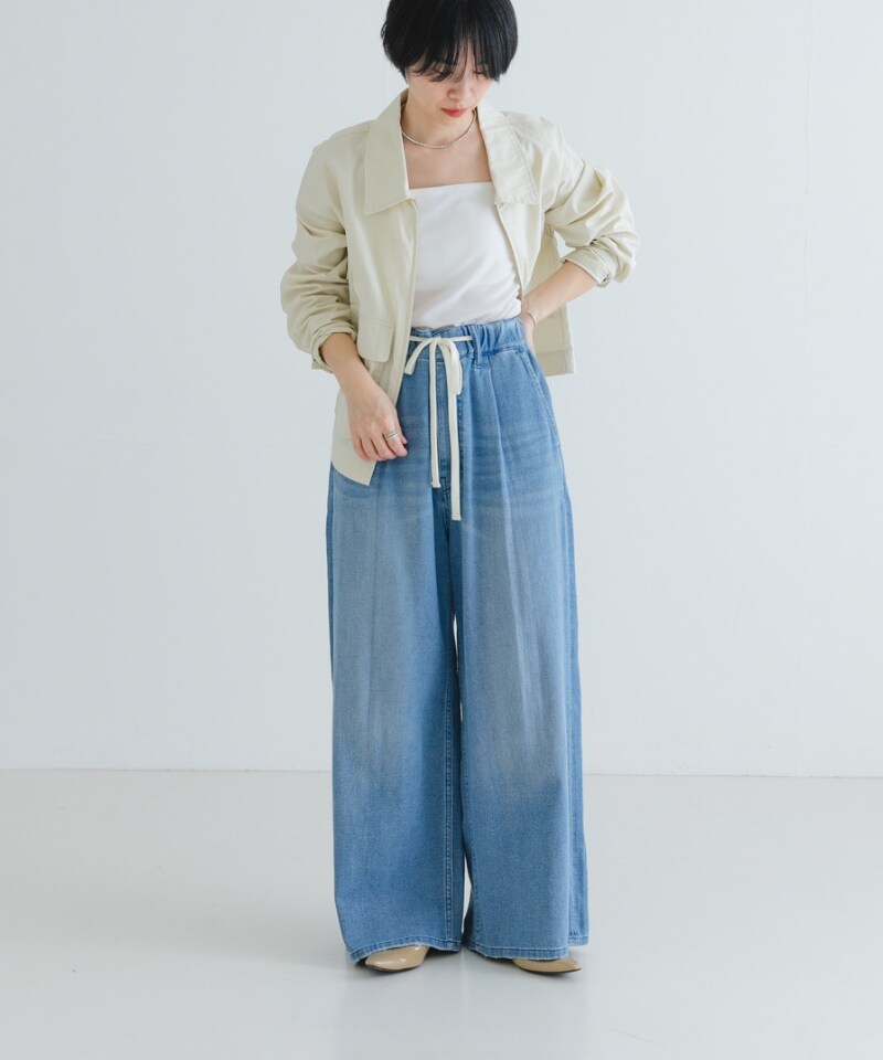 ベージュ系のパンプス、ホワイト系のブルゾン、ブルー系のデニムパンツを着用したレディースの春コーディネートの2枚目の写真