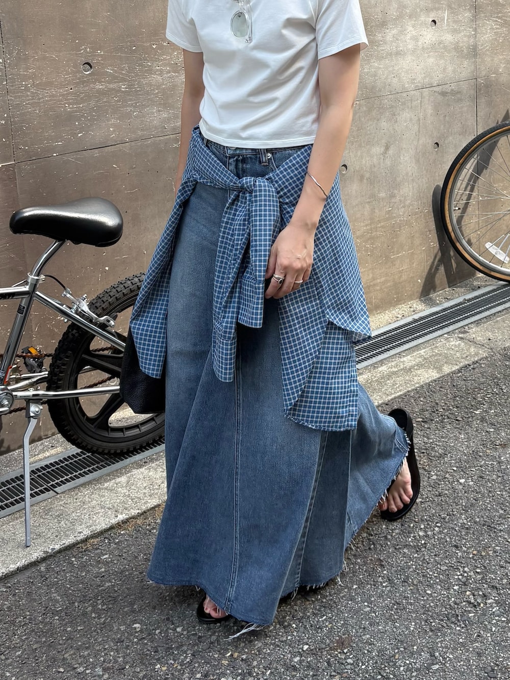 ブルー系のシャツ/ブラウス、ブラック系のトートバッグ、ブルー系のスカートを着用したレディースの夏コーディネートの2枚目の写真