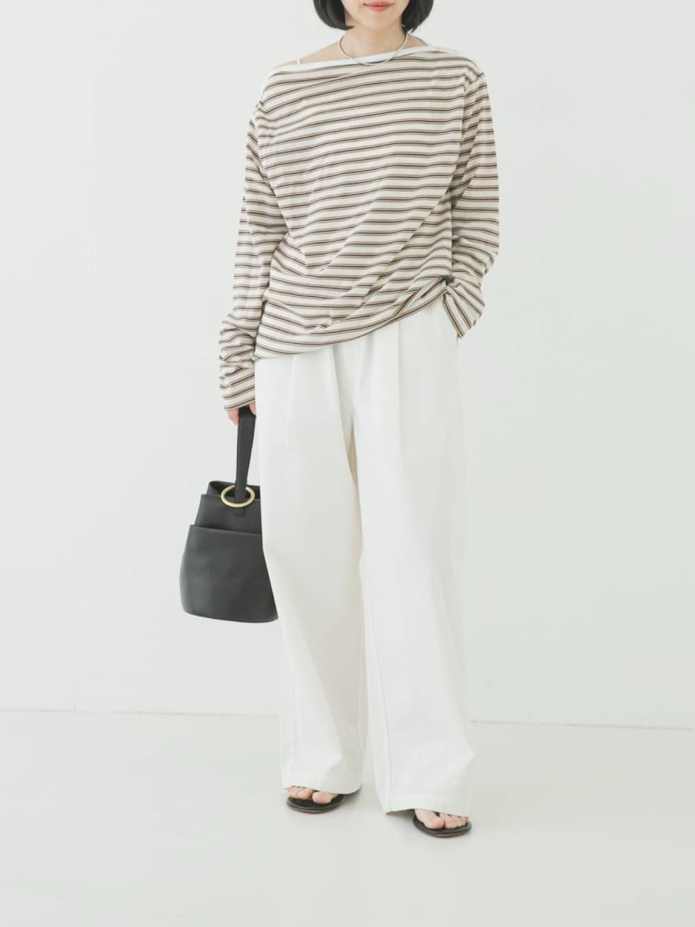 ホワイト系のTシャツ/カットソー、ブラック系のハンドバッグ、ホワイト系のその他パンツを着用したレディースの春コーディネートの2枚目の写真