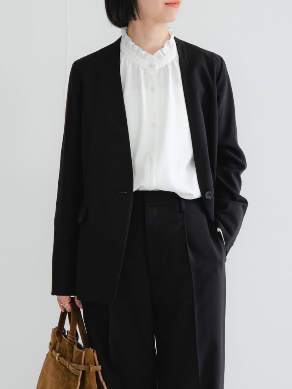 ブラック系のノーカラージャケット、ホワイト系のシャツ/ブラウス、ブラック系のその他パンツを着用したレディースの冬コーディネートの3枚目の写真